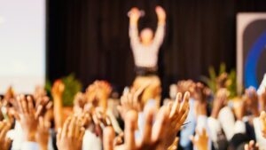 people raising hands with bokeh lights