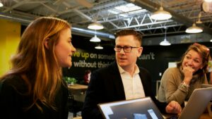 man and two women sitting beside table salespeople