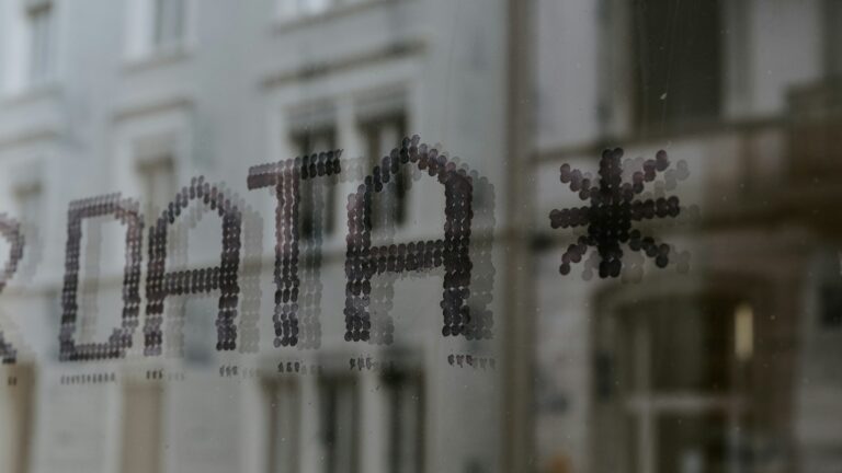 a close up of a window with a building in the background
