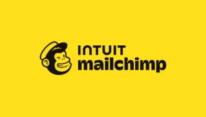 Intuit Mailchimp logo featuring a smiling monkey face with a hat beside the words "Intuit Mailchimp" on a yellow background, reflecting new tools and customer insights to help you grow your business.