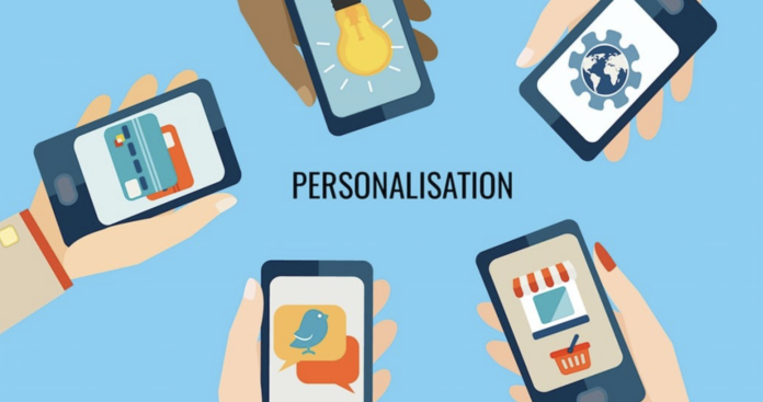 Illustration of five hands holding smartphones, each displaying different icons, with the word "PERSONALISATION" in the center on a blue background—highlighting how ABM campaigns leverage tailored mobile engagement.