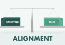 A balanced scale with boxes labeled "Marketing" and "Sales," illustrating the concept of sales-marketing alignment for effective lead generation between these two departments.